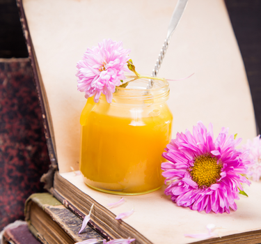 Blütenhonig creamy yellow im Glas mit Blume